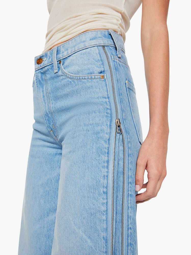 Close up view of a woman in a low-slung jeans can be worn two ways with a zipper on the outer seam that can be closed for a more narrow fit, and are designed with a zip fly, loose, wide leg and a long 32-inch inseam with a clean hem. 