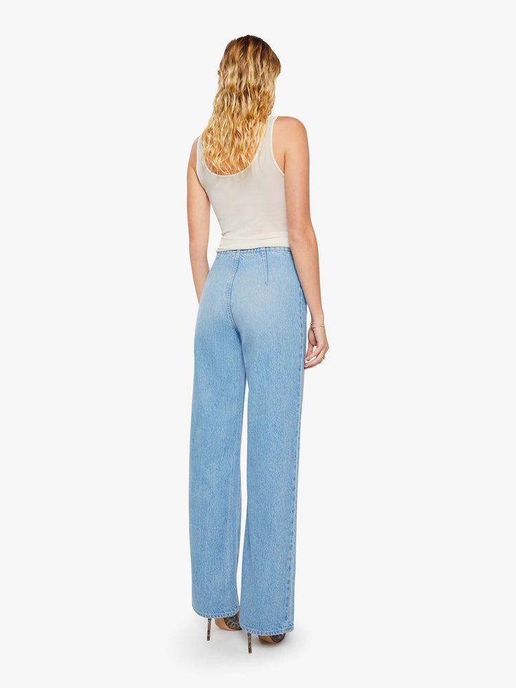 Back view of a woman in a light blue low-slung jeans are designed with a laced closure at the front, a side zip and a wide leg with a 32-inch inseam and a clean hem.