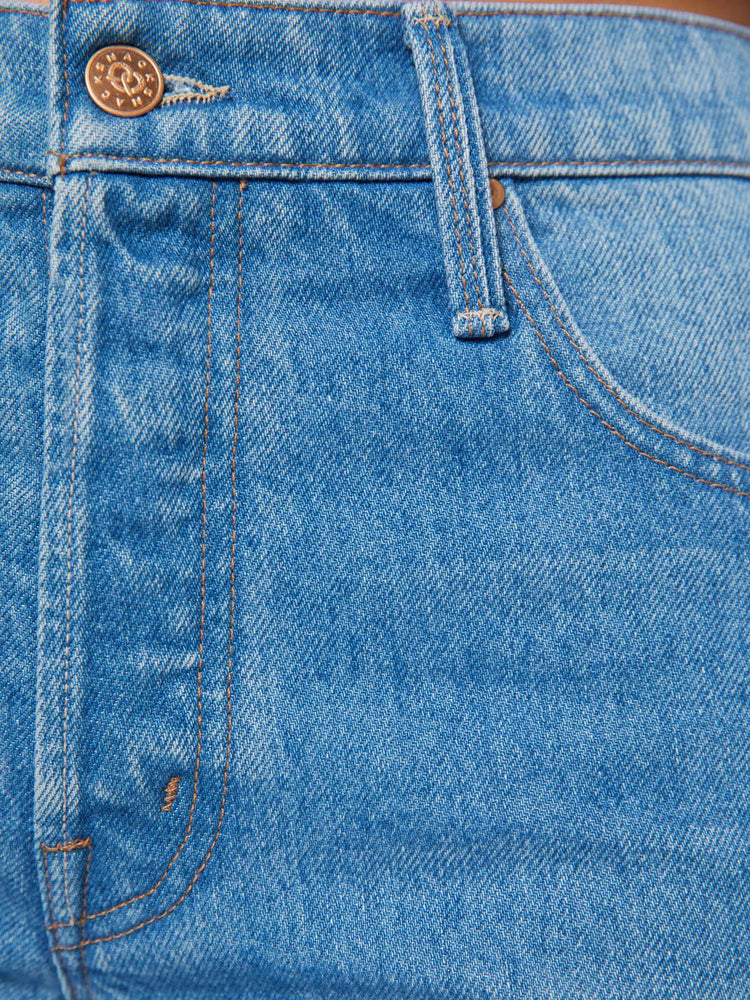 Swatch view of a woman in mid blue wide-leg jeans are designed with a button fly and a 26-inch inseam with a cuffed hem.