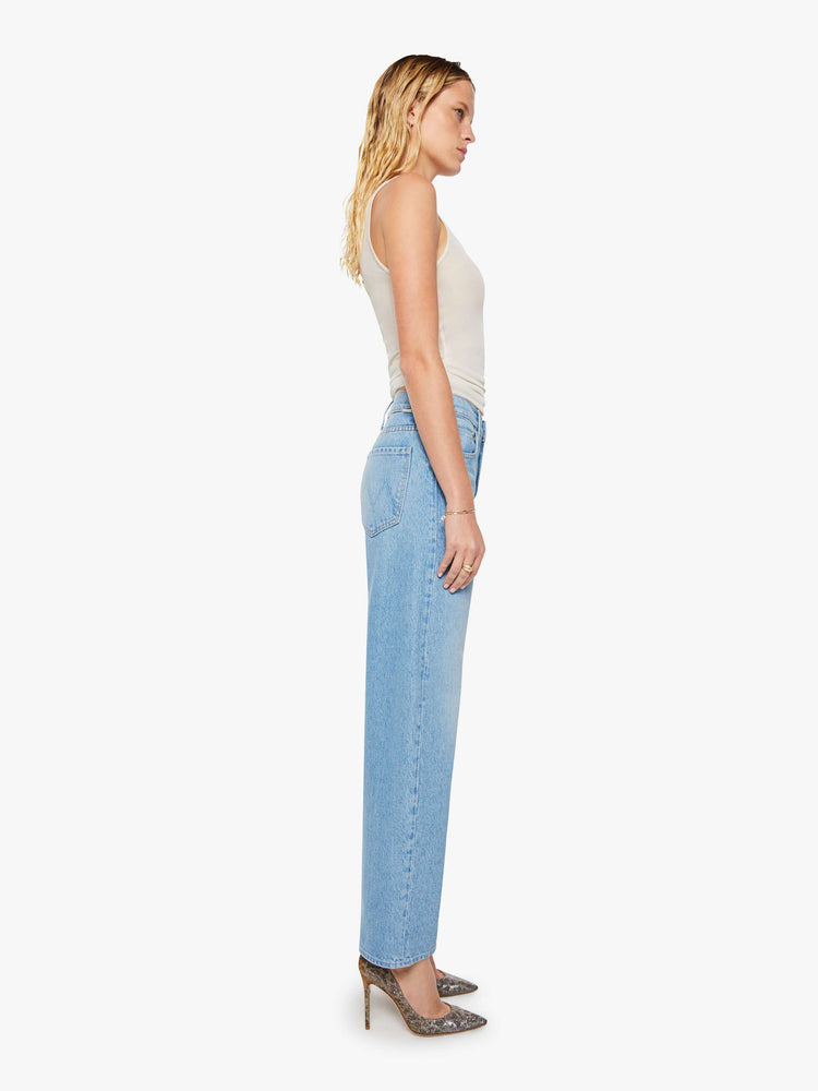 Side view of a woman in a light blue high-waisted jeans are designed with a zip fly, relaxed fit and a 31-inch inseam with a clean hem.