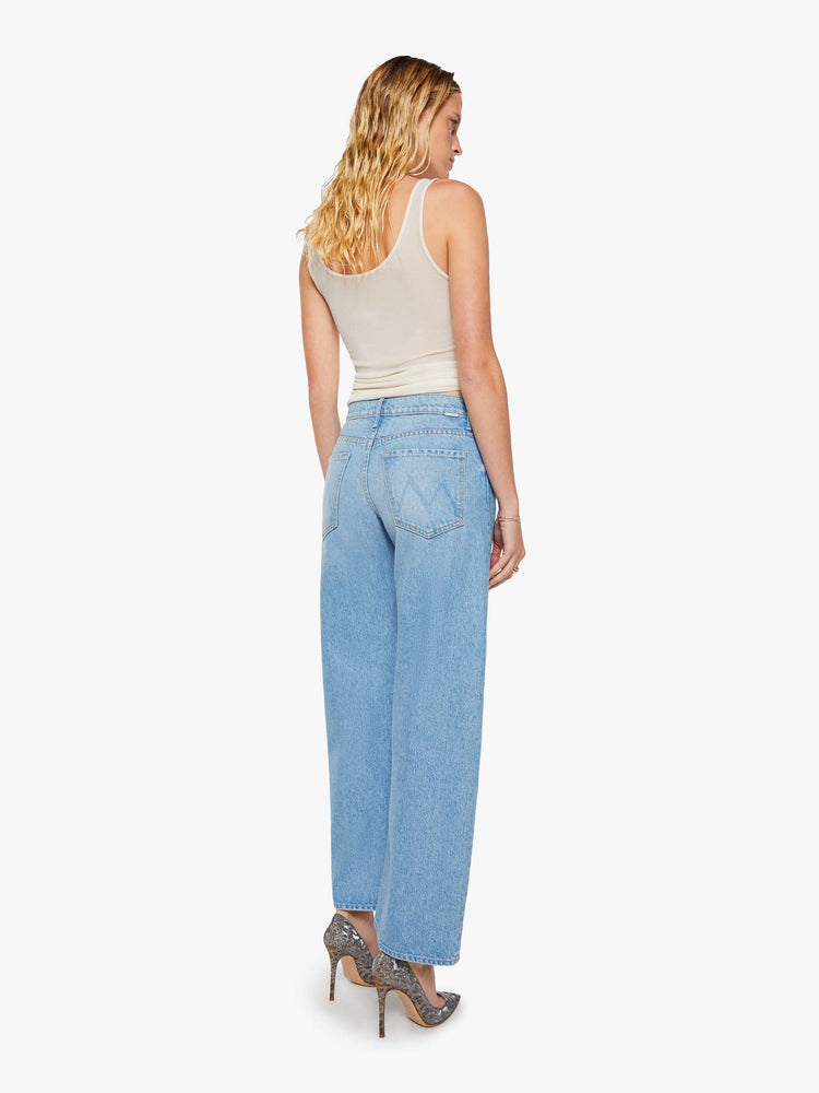 Back view of a woman in a light blue high-waisted jeans are designed with a zip fly, relaxed fit and a 31-inch inseam with a clean hem.