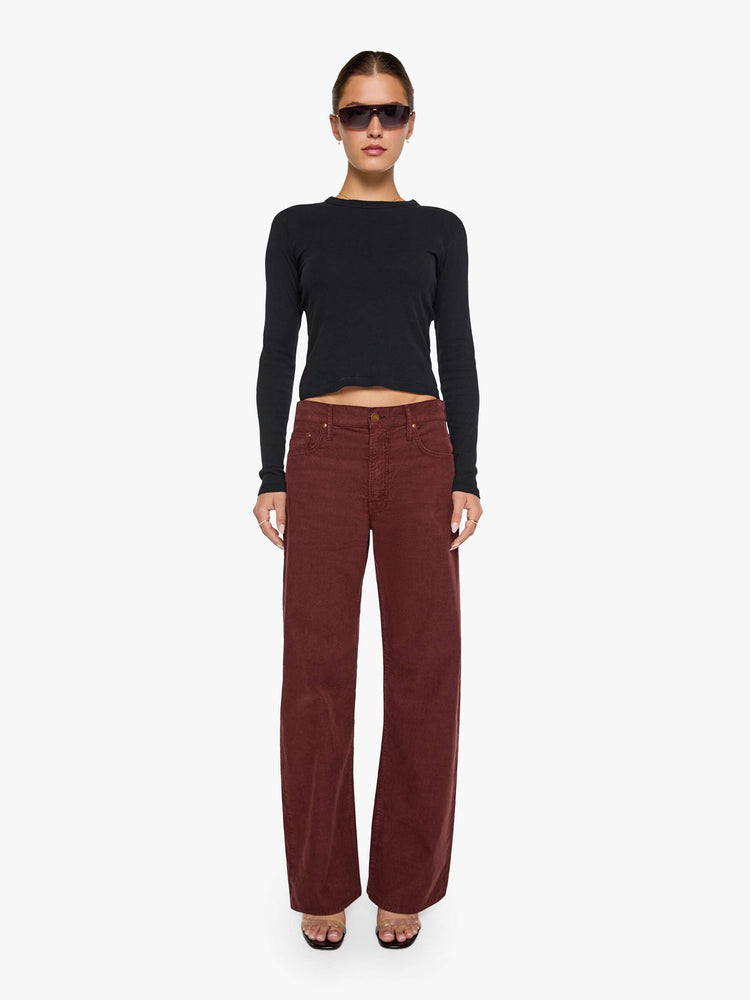 Front view of a woman in a merlot corduroy high-waisted jeans are designed with a zip fly, relaxed fit and a 31-inch inseam with a clean hem.