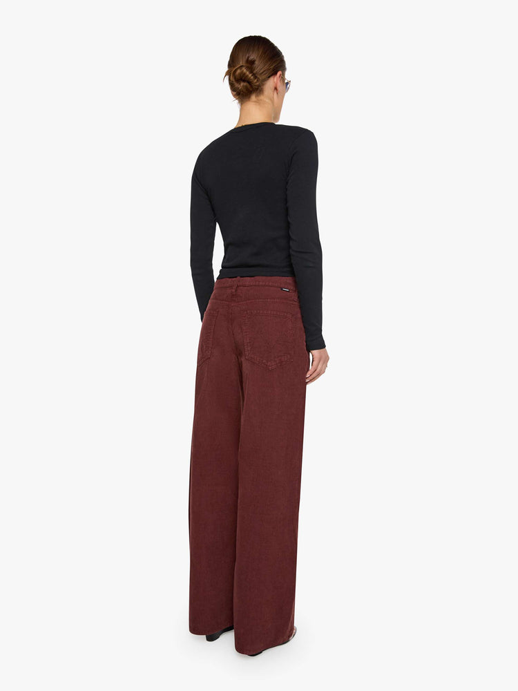 Back view of a woman in a merlot corduroy high-waisted jeans are designed with a zip fly, relaxed fit and a 31-inch inseam with a clean hem.