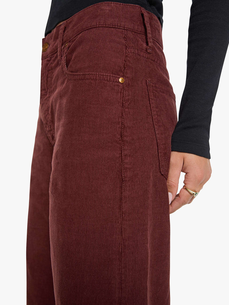 Waist close up view of a woman in a merlot corduroy high-waisted jeans are designed with a zip fly, relaxed fit and a 31-inch inseam with a clean hem.