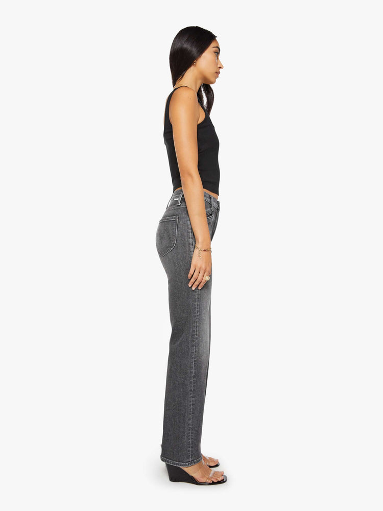 Side view of a woman in a dark grey high-rise jeans with a straight leg, zip fly, curved patch pockets with slit openings and a 32-inch inseam with a clean hem.
