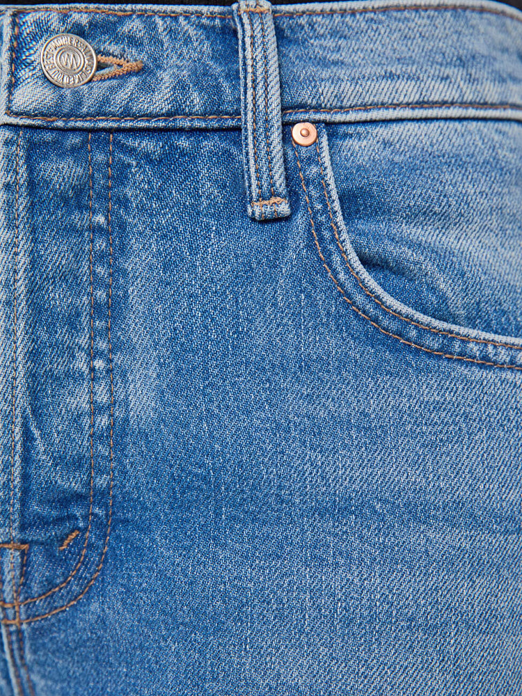 Swatch view of a woman in a med blue high-waisted wide leg jeans with a zip fly, a long 31-inch inseam and loose, low-slung fit. 