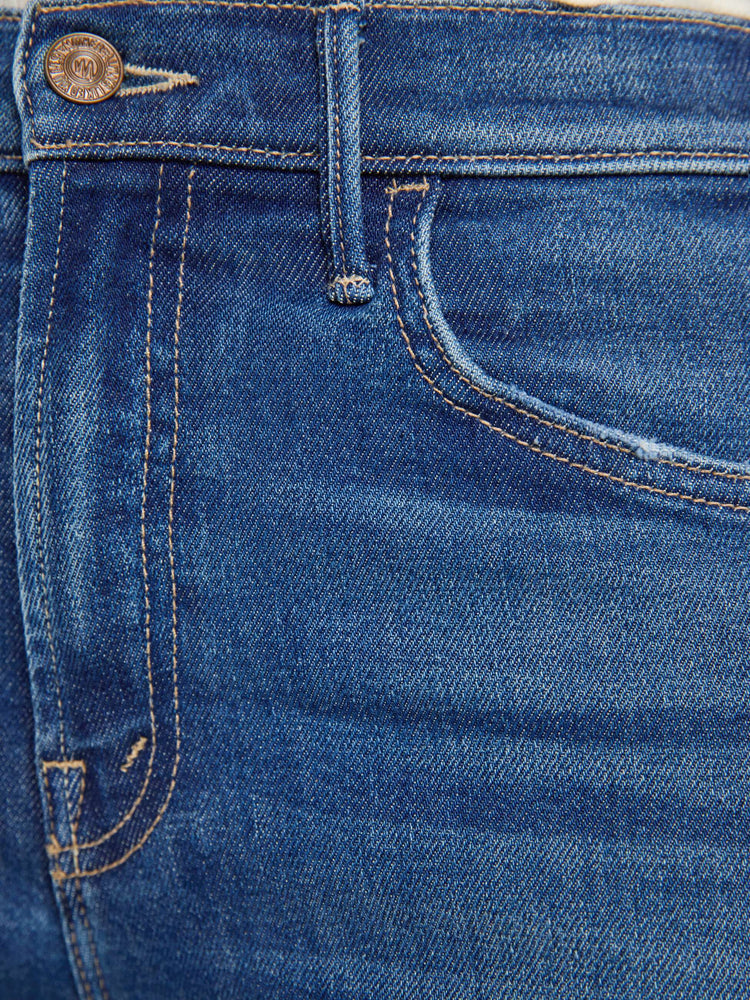 Swatch view of a woman in a mid blue wide leg jeans with a high rise, zip fly, double-stitched side seam, 32-inch inseam and a clean hem.