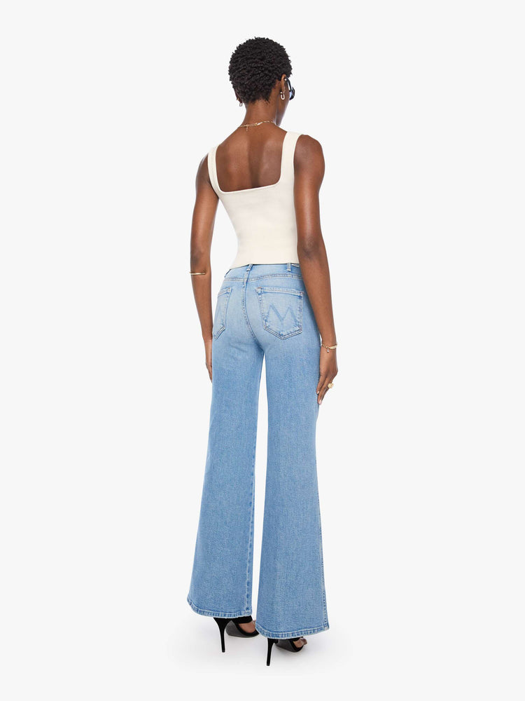 Back view of a woman in a light blue wide leg jeans with a high rise, 32-inch inseam and a clean hem.