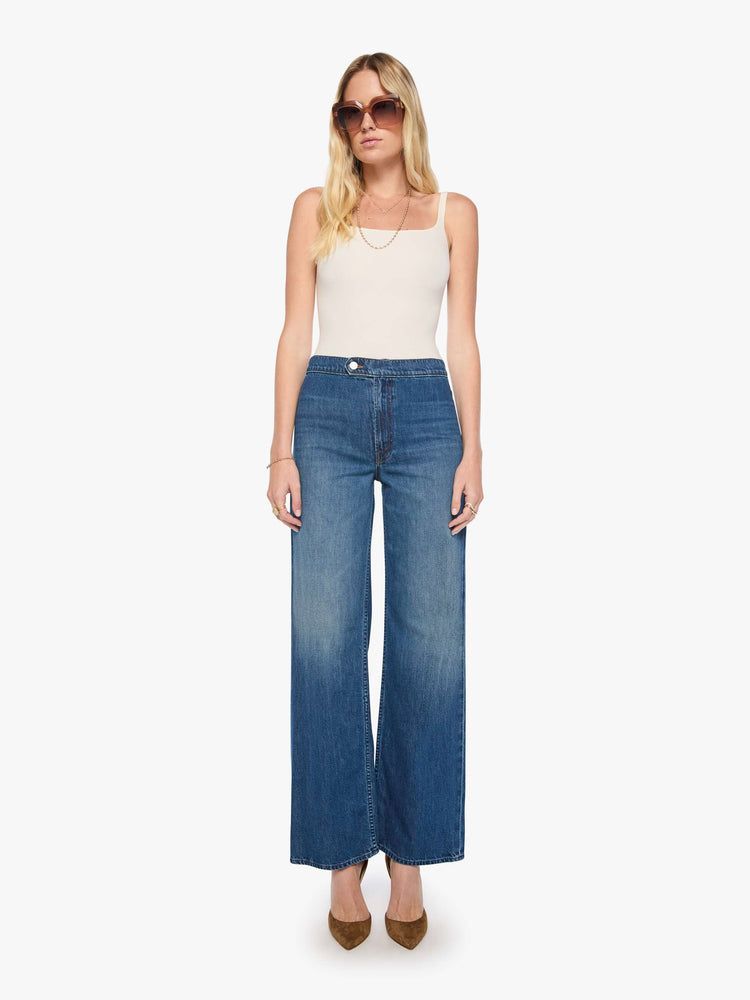 Front view of a woman in med blue high-rise wide-leg jeans with a zip fly, button-tab waistband, a long 32-inch inseam and a loose, low-slung fit. 