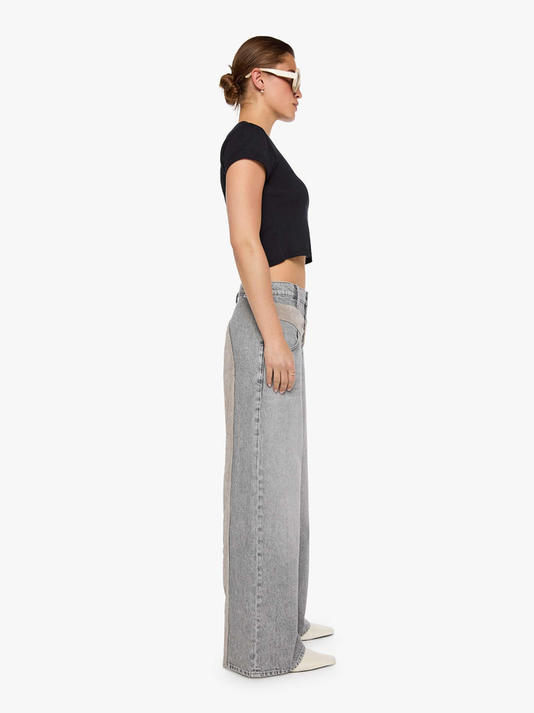 Side view of a woman in a washed grey high-rise pants are designed with an inset corduroy panel at the waist and down the back legs, an exposed button fly, low-slung fit and a 30-inch inseam with a clean hem.