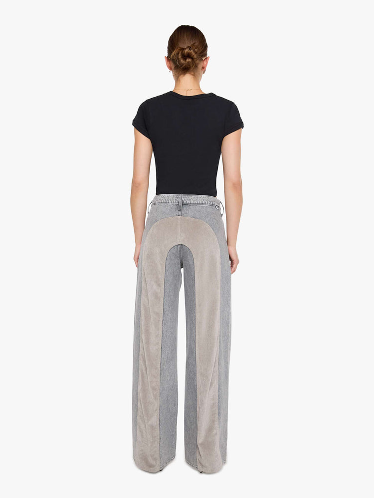 Back view of a woman in a washed grey high-rise pants are designed with an inset corduroy panel at the waist and down the back legs, an exposed button fly, low-slung fit and a 30-inch inseam with a clean hem.
