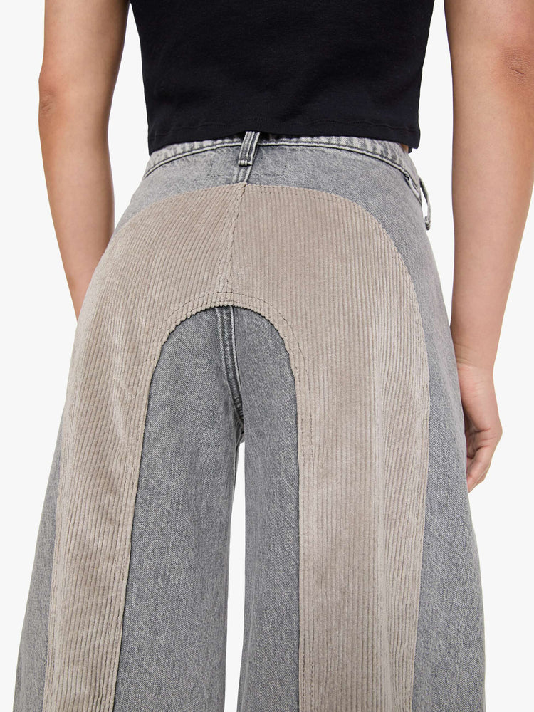 Back close up view of a woman in a washed grey high-rise pants are designed with an inset corduroy panel at the waist and down the back legs, an exposed button fly, low-slung fit and a 30-inch inseam with a clean hem.