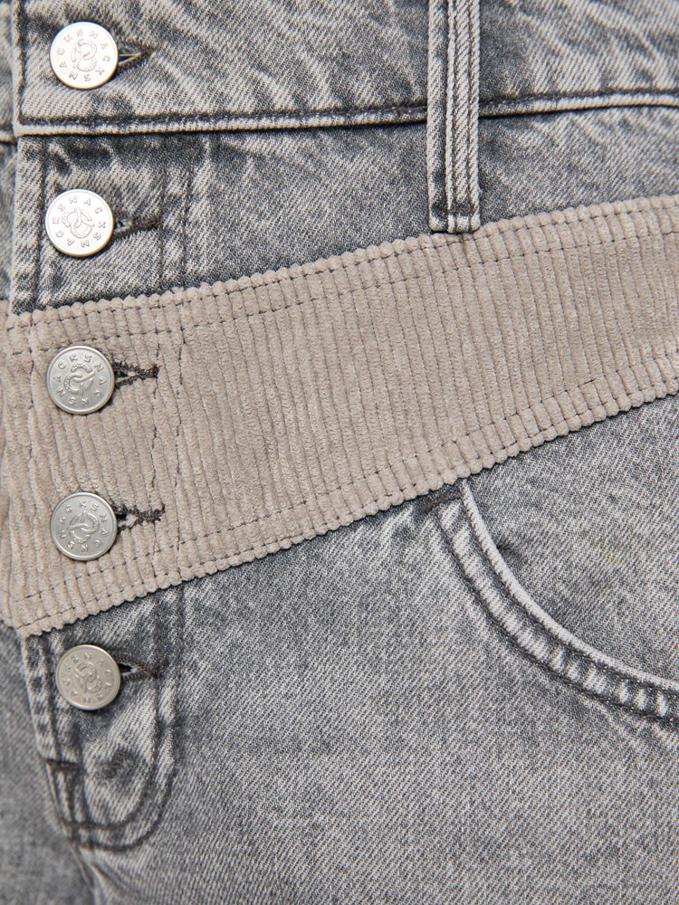 Swatch view of a woman in a washed grey high-rise pants are designed with an inset corduroy panel at the waist and down the back legs, an exposed button fly, low-slung fit and a 30-inch inseam with a clean hem.