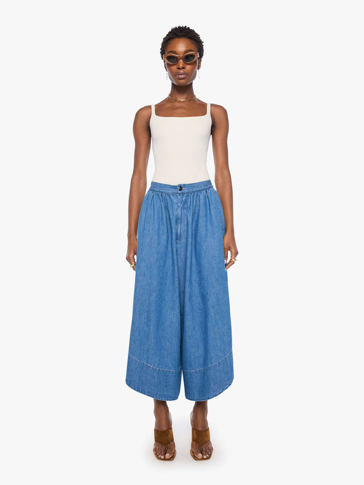 Front view of a woman in a super high-waisted wide-leg pants with a zip fly, relaxed fit, slit pockets, a curved side slit on the outer hems and a short 24-inch inseam.