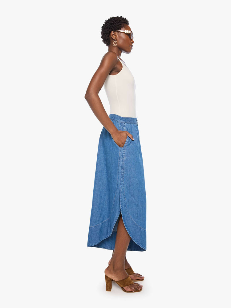 Side view of a woman in a super high-waisted wide-leg pants with a zip fly, relaxed fit, slit pockets, a curved side slit on the outer hems and a short 24-inch inseam.