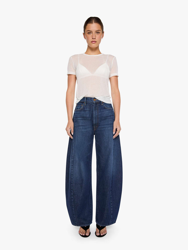Front view of a woman in a super high-waisted jeans are designed with a zip fly, an inset panel on the outer seam, slightly tapered leg, 30-inch inseam, clean hem and a relaxed fit. 