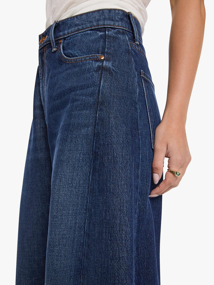 Close up view of a woman in a super high-waisted jeans are designed with a zip fly, an inset panel on the outer seam, slightly tapered leg, 30-inch inseam, clean hem and a relaxed fit. 