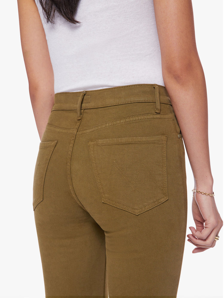 Close up waist view of a woman skinny flare with a high rise and a full-length inseam with a sliced hem in a fir green hue.
