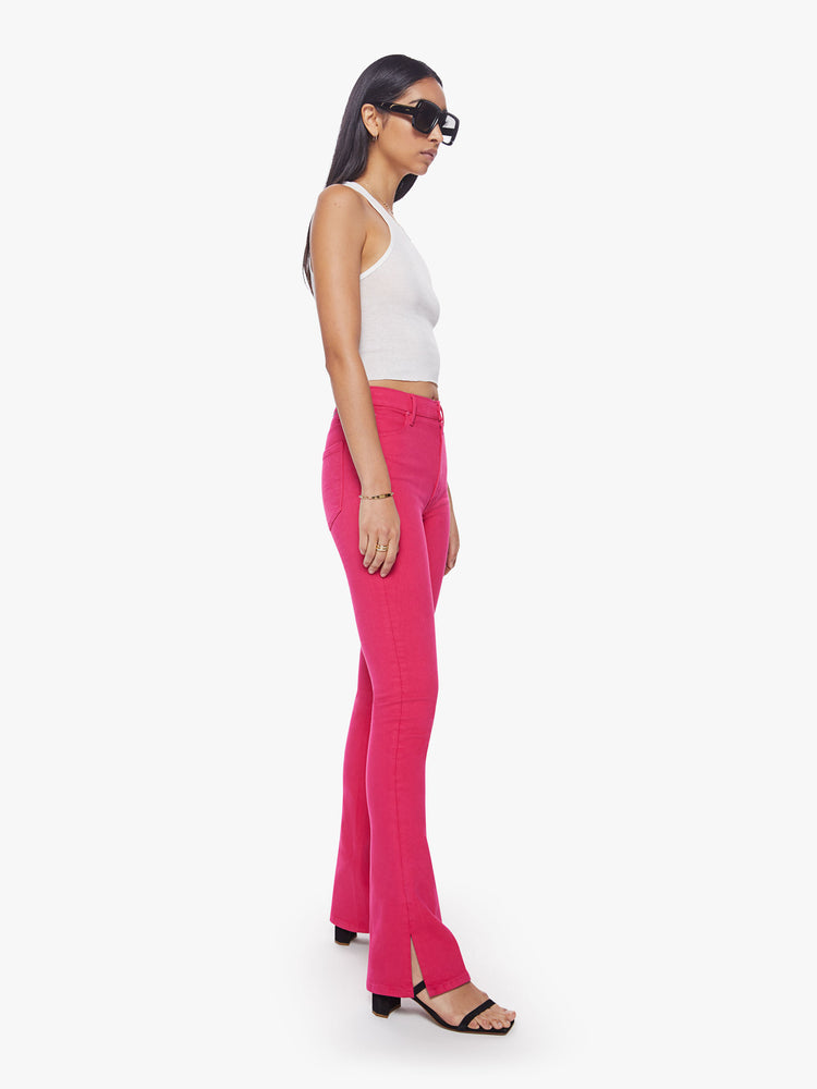 Side angle view of a classic skinny flare with a high rise and a full-length inseam with a sliced hem in a hot pink hue.