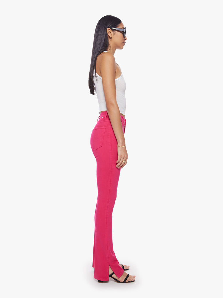 Side view of a classic skinny flare with a high rise and a full-length inseam with a sliced hem in a hot pink hue.