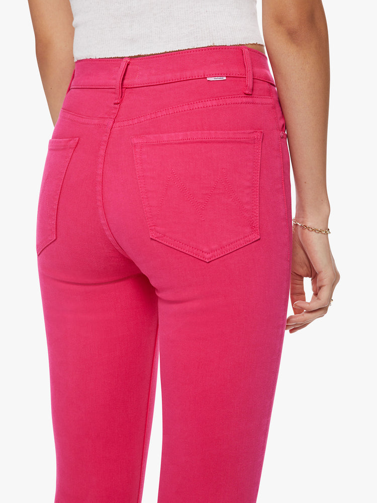 Close up back view of a classic skinny flare with a high rise and a full-length inseam with a sliced hem in a hot pink hue.