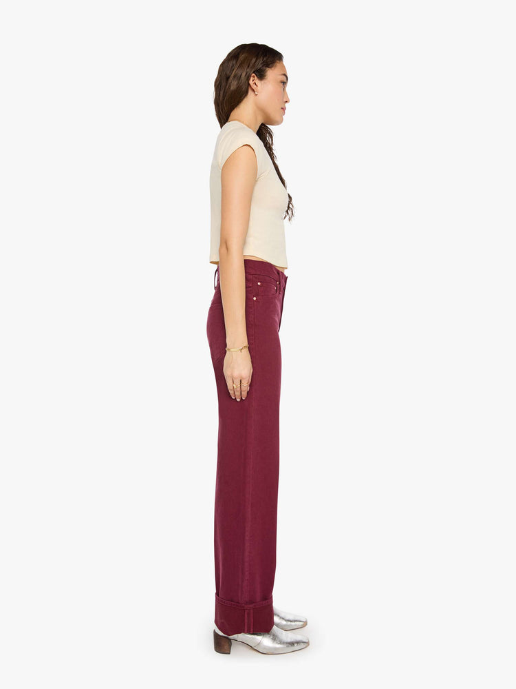 Side view of a woman in pants designed to sit lower on the hips with a mid rise, zip fly, loose straight leg and a clean 31-inch inseam with a cuffed hem.