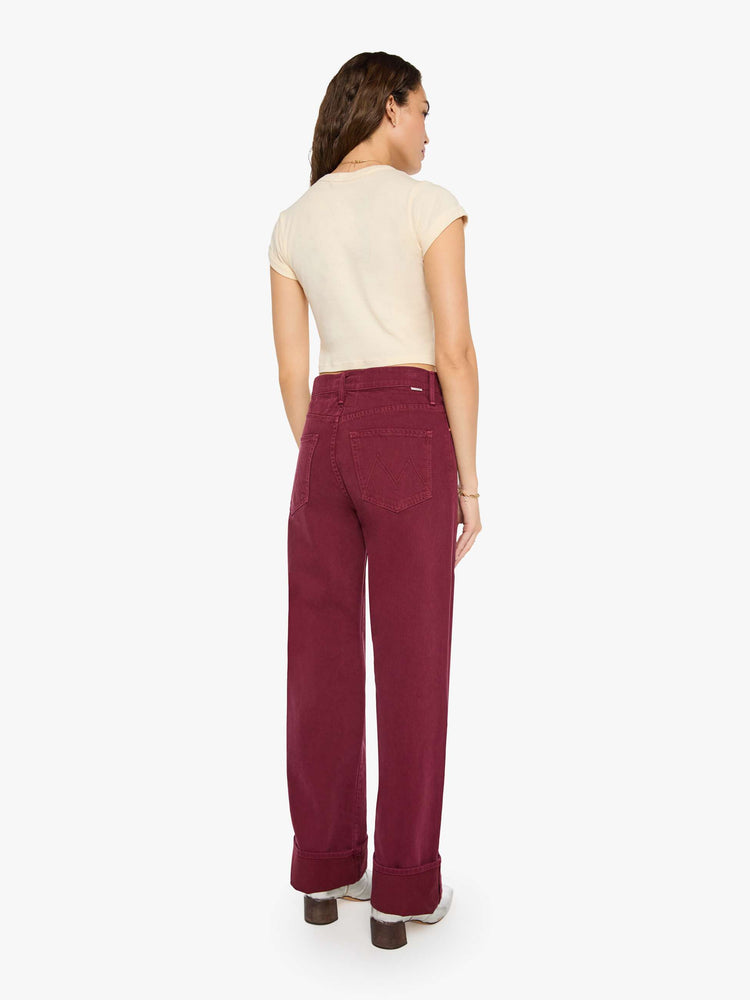 Back view of a woman in pants designed to sit lower on the hips with a mid rise, zip fly, loose straight leg and a clean 31-inch inseam with a cuffed hem.