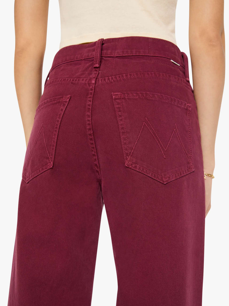 Close up view of a woman in pants designed to sit lower on the hips with a mid rise, zip fly, loose straight leg and a clean 31-inch inseam with a cuffed hem.