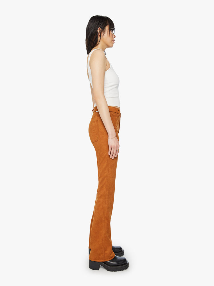 Side view of a woman mid-rise bootcut pants with front patch pockets, a long 34-inch inseam and a slightly slouchy fit in a light brown faux suede.