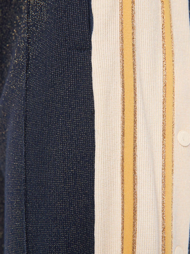 Swatch  view of a woman in a metallic navy with cream and golden yellow stripes down the legs wide-leg track pants with an elastic waistband, loose leg and a contrast side stripe with buttons down the outer seams. 