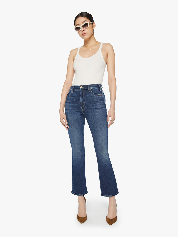 Front view of a woman high-rise flare has an ankle-length inseam and a clean hem in a dark blue wash.