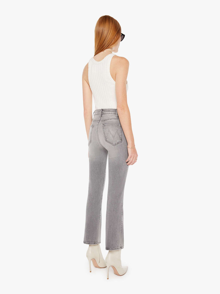 Back view of a womens grey wash jean featuring a high rise and an ankle length flare leg.