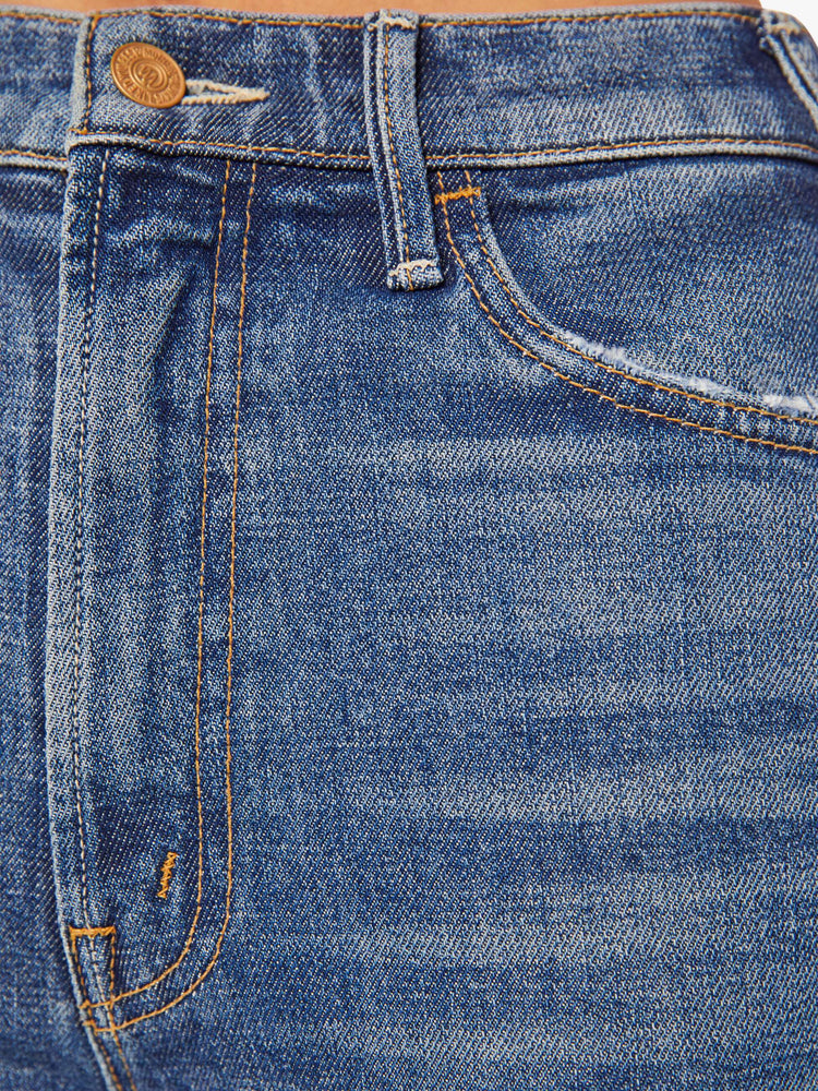 Swatch view of a woman in a mid-blue high-rise flare has a zip fly, ankle-length inseam and a clean hem.