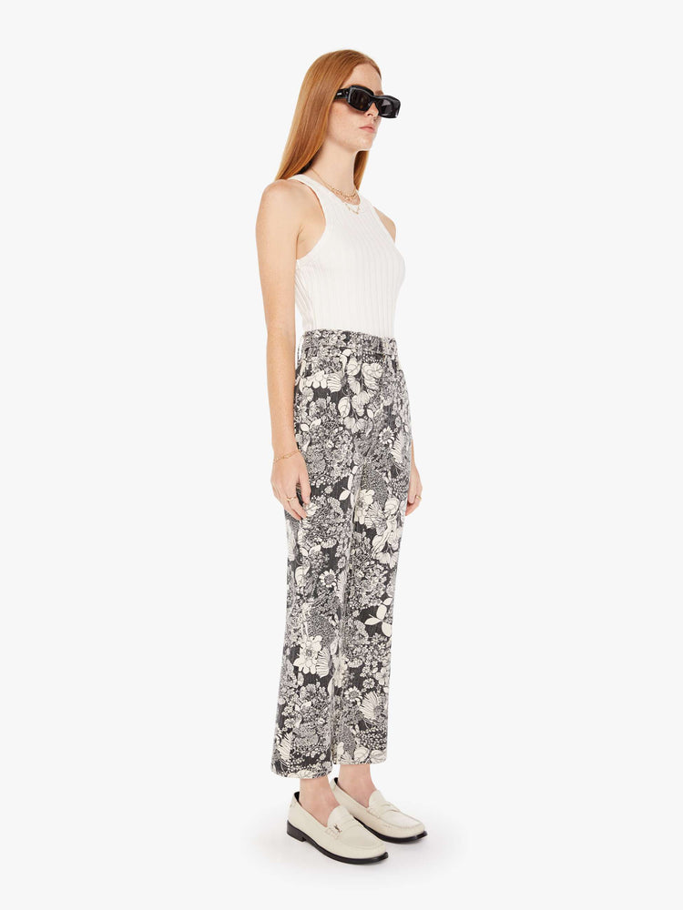 Front 3/4 view of a womens high rise flare jean featuring an all over black and white print of flowers.