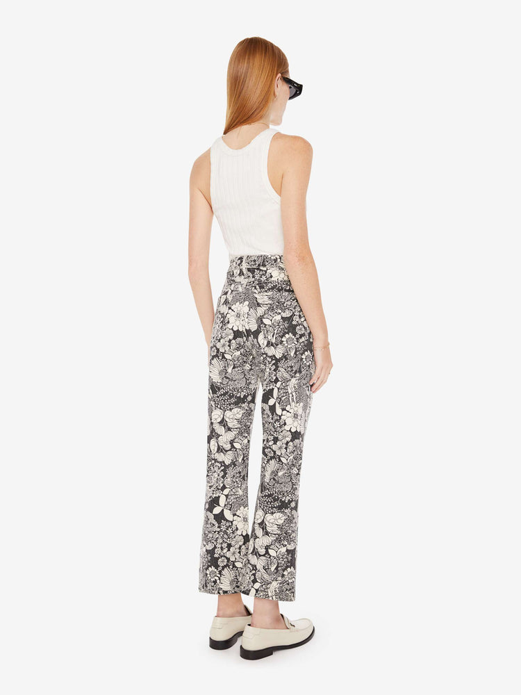 Back view of a womens high rise flare jean featuring an all over black and white print of flowers.