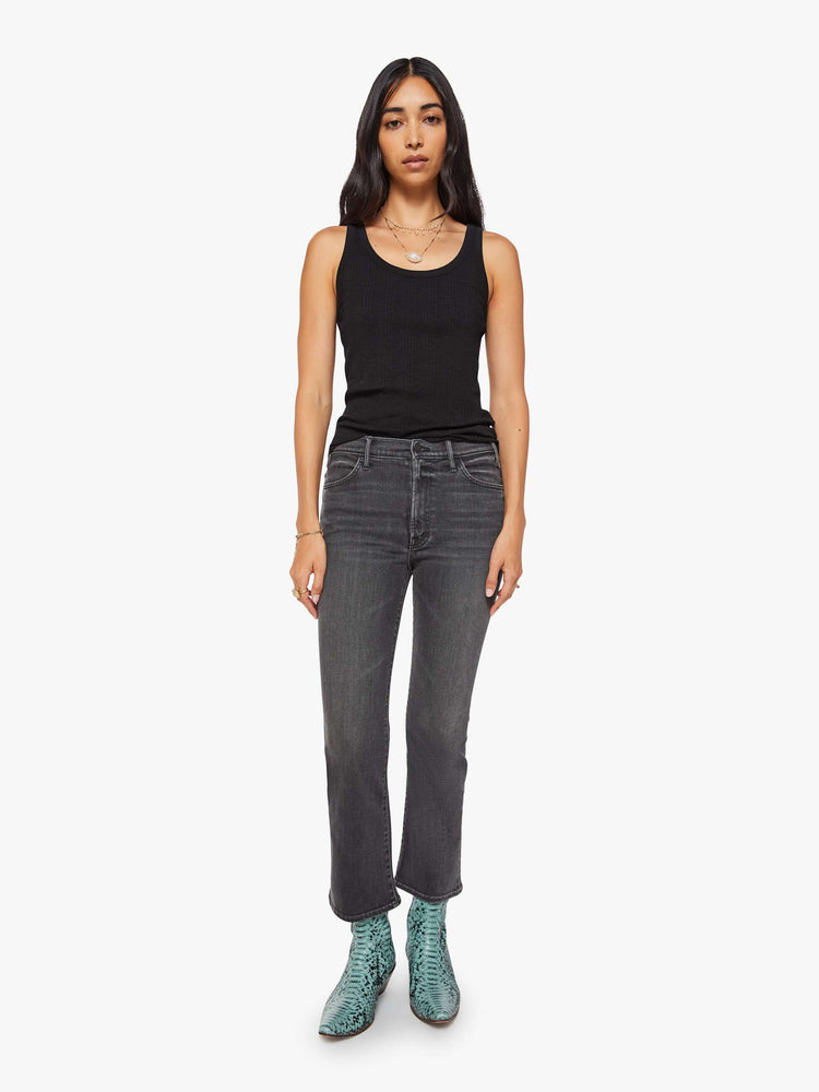 Front view of a woman in a faded grey high-rise flare has an ankle-length inseam and a clean hem.