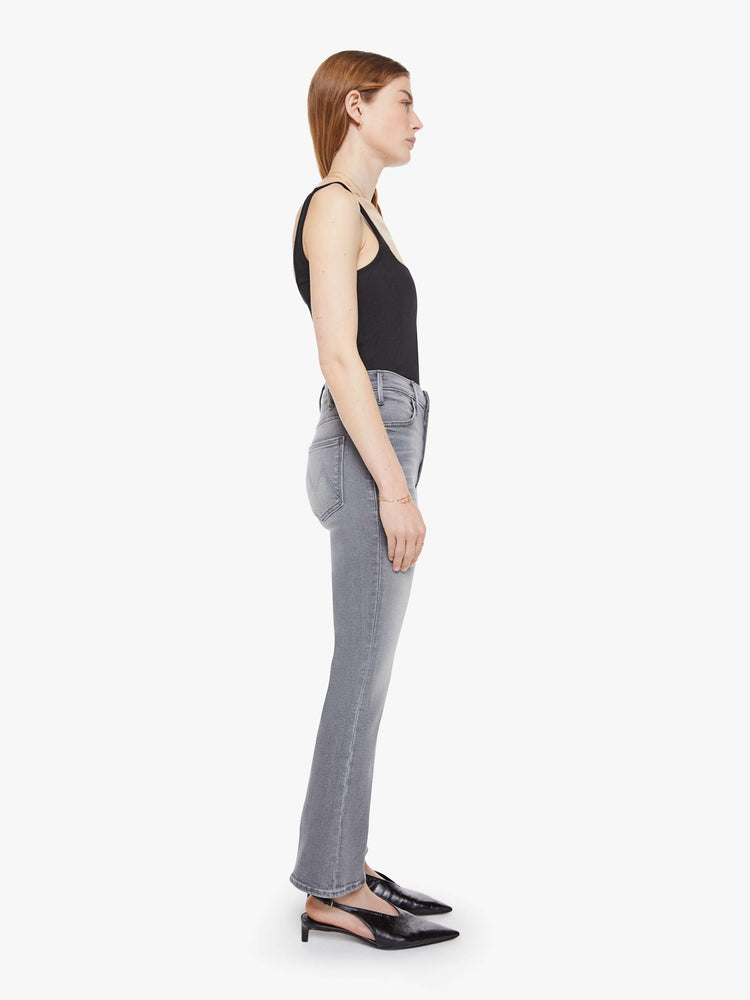 Side view of a woman in a grey high-rise flare has a zip fly, ankle-length inseam and a clean hem.