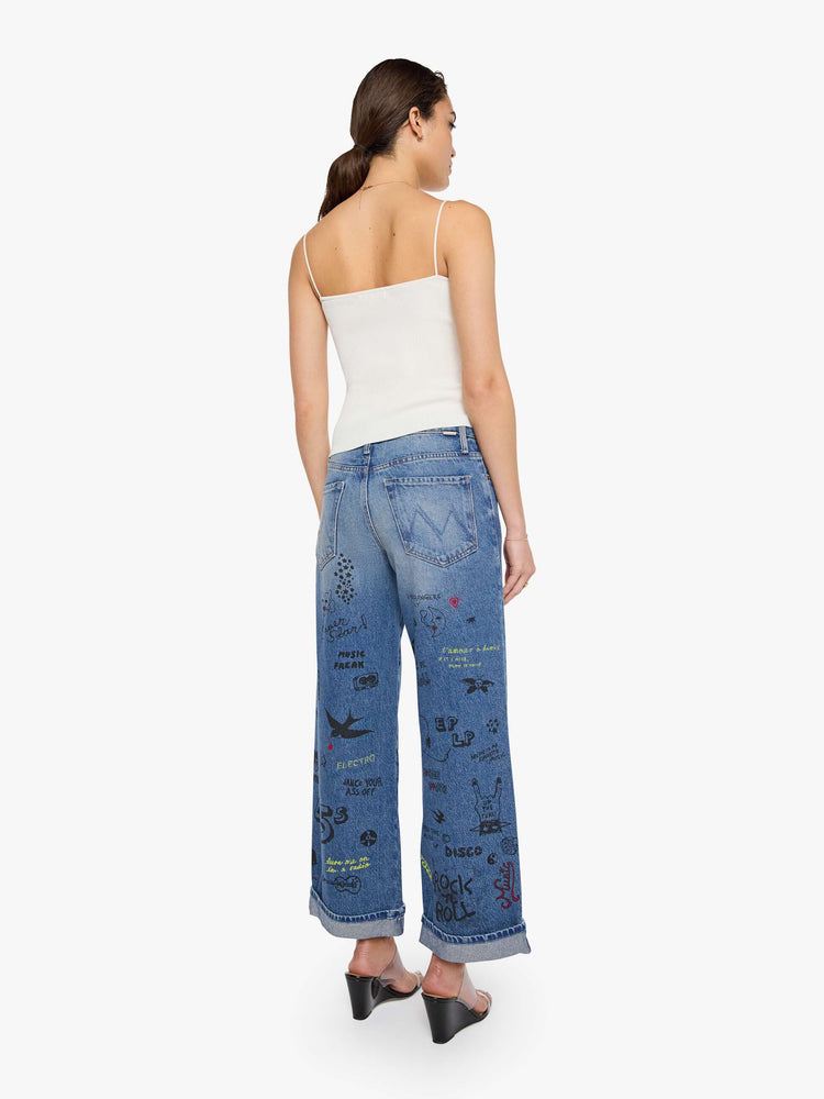Back view of a woman in a wide-leg jeans are designed with a zip fly, low slung fit and a 28.25-inch inseam with a cuffed hem.