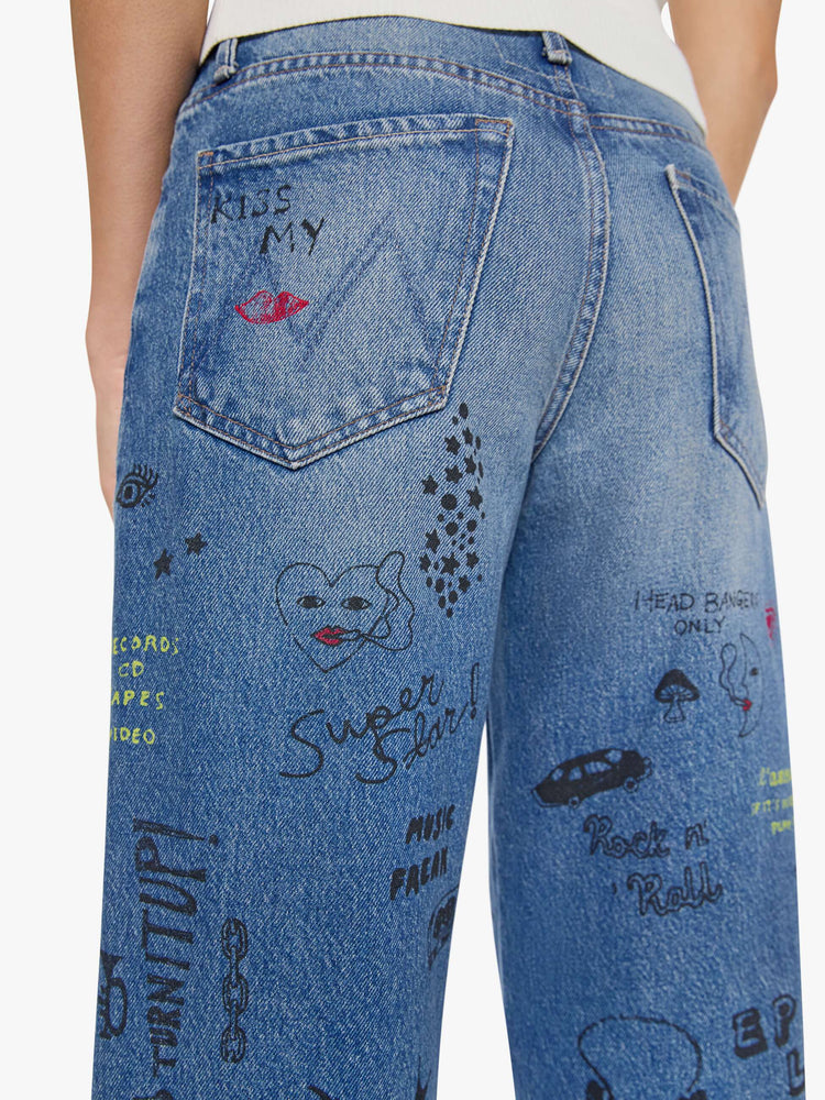 Back view of a woman in a wide-leg jeans are designed with a zip fly, low slung fit and a 28.25-inch inseam with a cuffed hem.