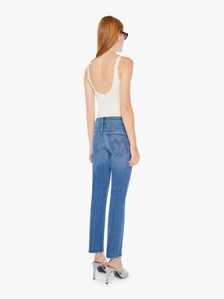 Back view of a womens medium blue wash jean featuring a mid rise, straight leg, and a ankle length frayed hem.