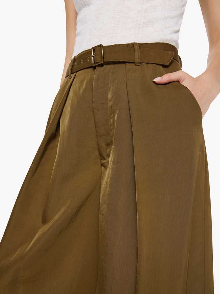 Close up view of a woman in a bronze super high-waisted pants with a belted waistband, zip fly, curved leg, slit pockets, pleats for an even wider fit, and a long inseam with a clean hem.