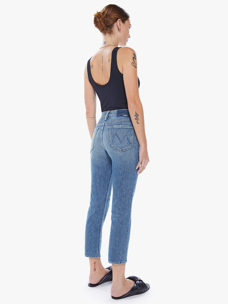Back view of a womens medium blue wash jean featuring a high rise, straight leg, and a clean cropped hem.