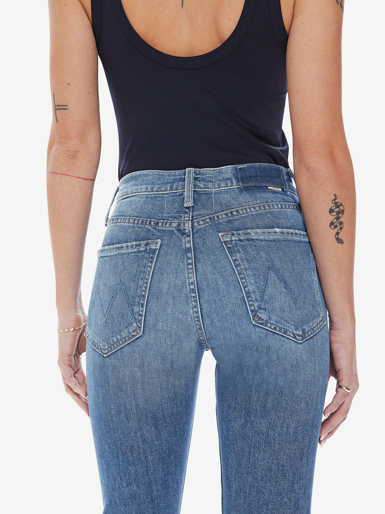 Back close up view of a womens medium blue wash jean featuring a high rise, straight leg.