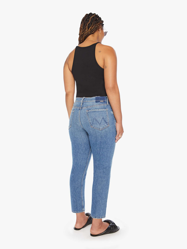Back view of a womens medium blue wash jean featuring a high rise, straight leg, and a clean cropped hem.