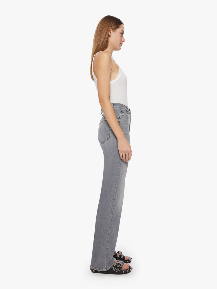 Side view of a woman super high-waisted jeans with a loose fit, wide leg and 34-inch inseam with a clean hem in a grey hue.