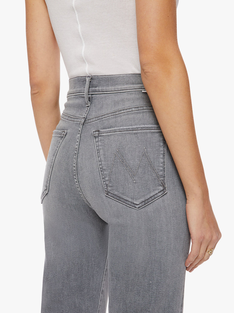 Close up view of a woman super high-waisted jeans with a loose fit, wide leg and 34-inch inseam with a clean hem in a grey hue.