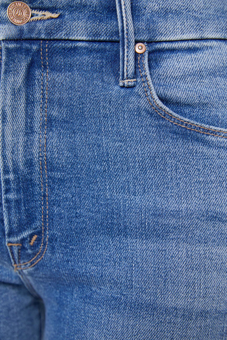 Swatch view of a woman in a mid blue high waisted wide leg jean with a 31-inch inseam and a frayed hem.