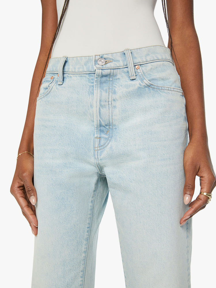 Close up view of a woman cropped jeans with a button fly, slouchy straight leg and relaxed fit in a light blue wash.