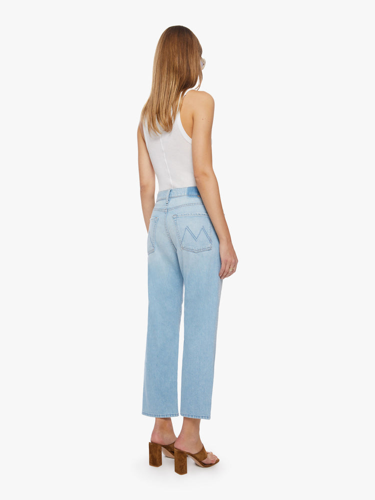 Back view of a woman cropped jeans with a button fly, slouchy straight leg and relaxed fit in a light blue.