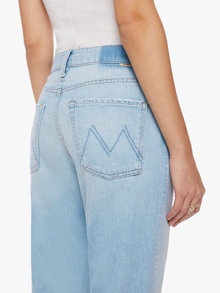 Back close up view of a woman cropped jeans with a button fly, slouchy straight leg and relaxed fit in a light blue.
